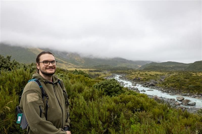 OMNR student Garrett Harrison standing in field by water