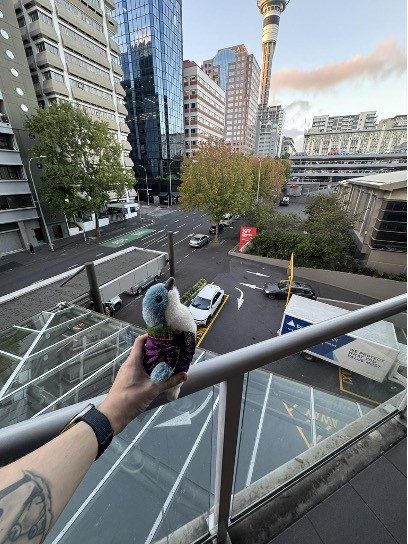 stuffed toy bird in front of downtown city