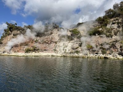 steam rising out of ground by body of water