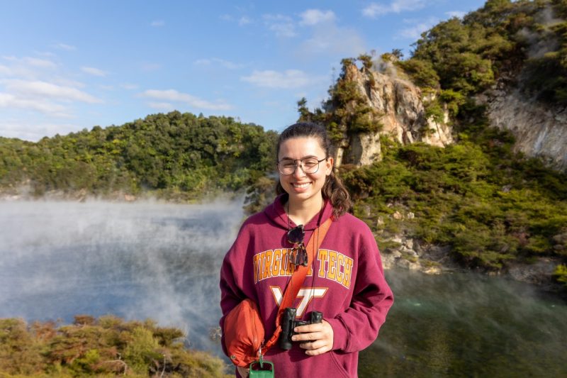 woman in a virginia tech sweatshirt stands in front of a geothermic lake