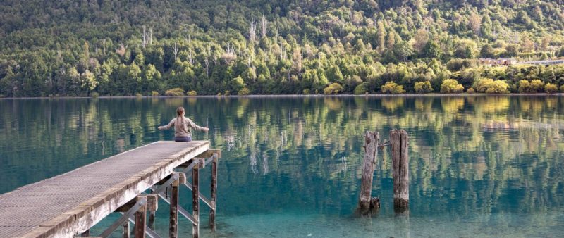 female student sitting on edge of water
