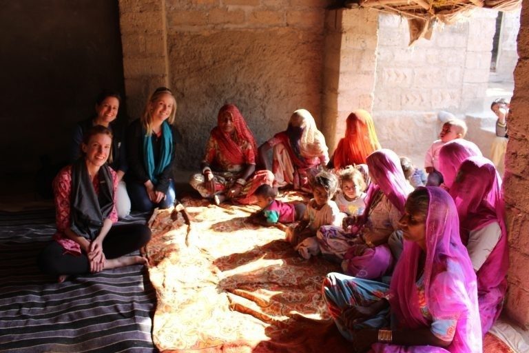 XMNR students engaging with women and children in a village in India during global study trip