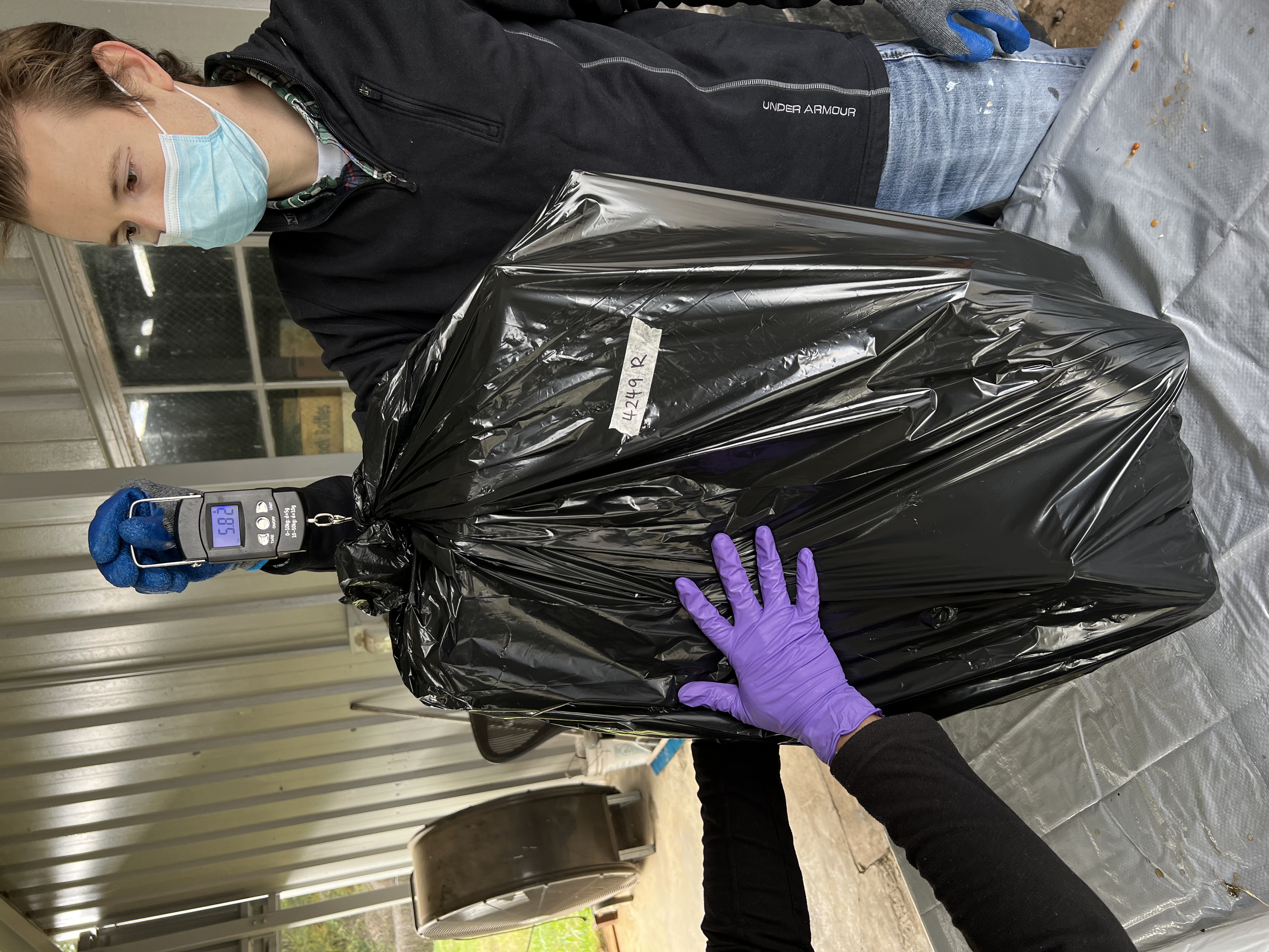 Patton weighing a bag of trash as a part of a waste audit
