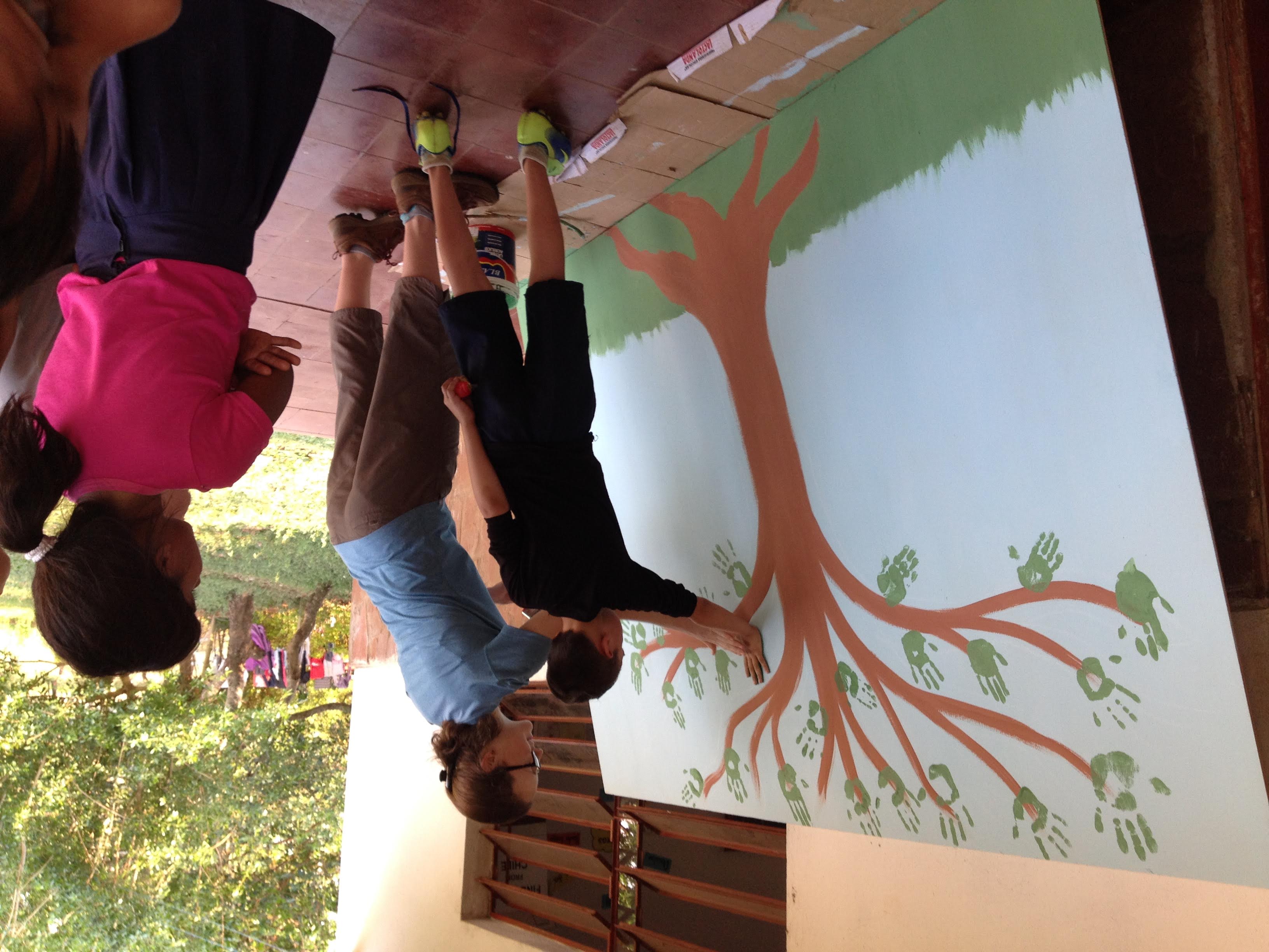 Bridget Johnson makes an environmentally-themed mural with kids at an elementary school in Paraguay during her Peace Corps service. 